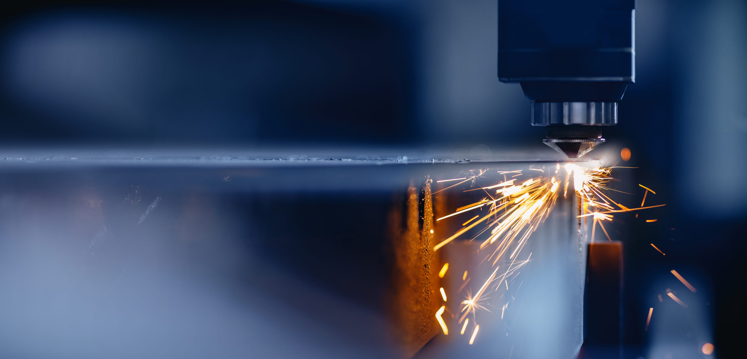 Blue color Laser CNC cut of metal with light spark, technology modern industrial