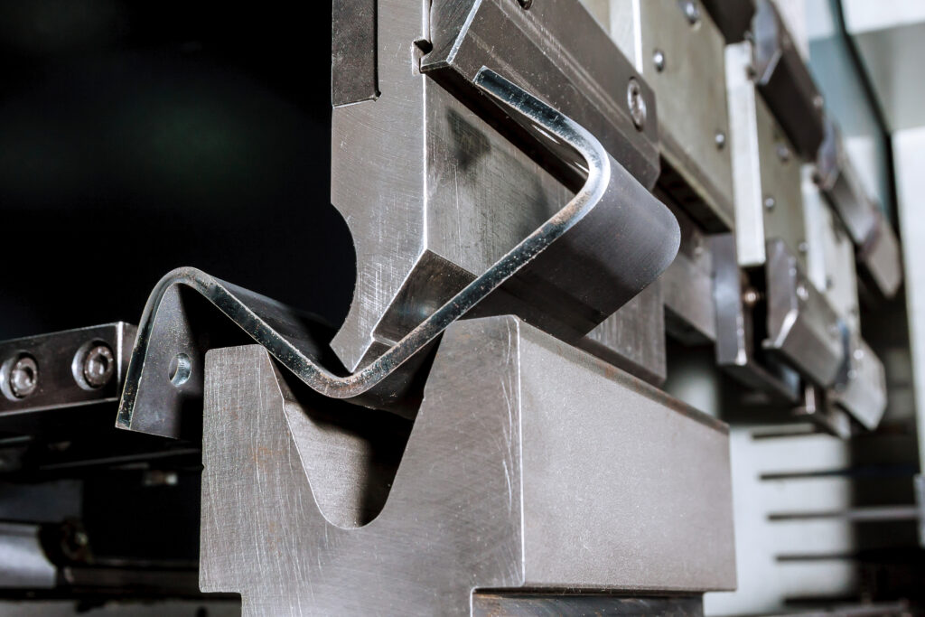 The process of bending sheet metal on a hydraulic bending machine. Metalworking plant.